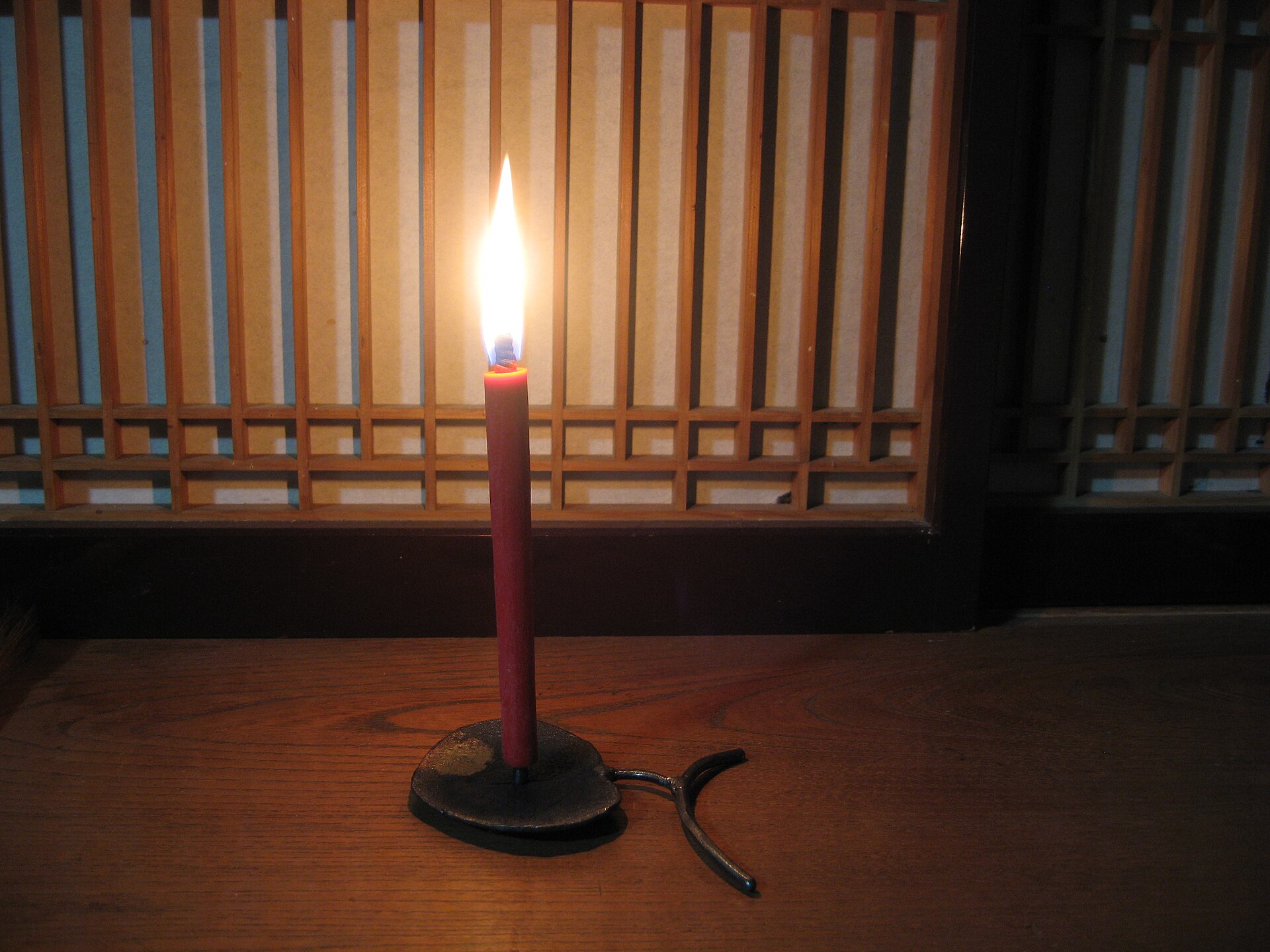 A Japanese warousoku candle made from sumac wax sitting in a traditional shokudai candlestick.